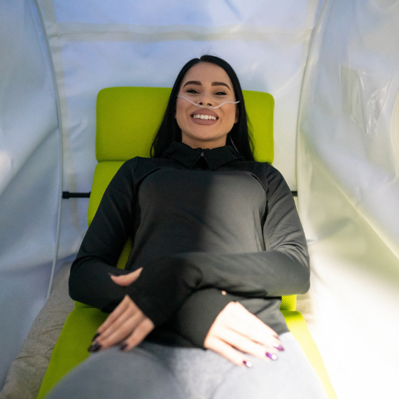 Woman sitting in hyperbaric therapy tent